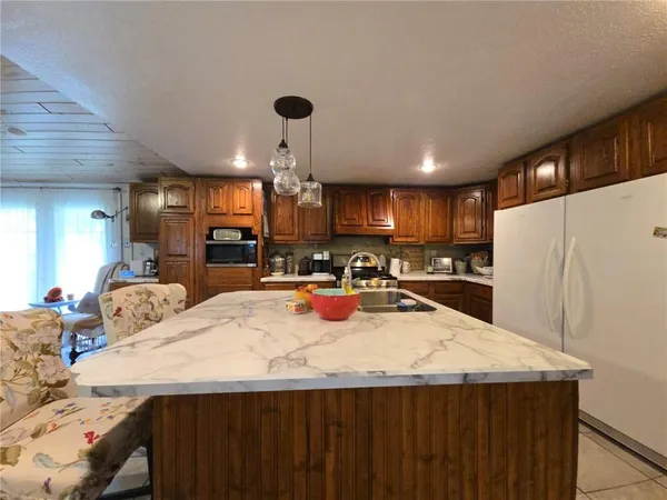 a kitchen with stainless steel appliances granite countertop a sink refrigerator and cabinets