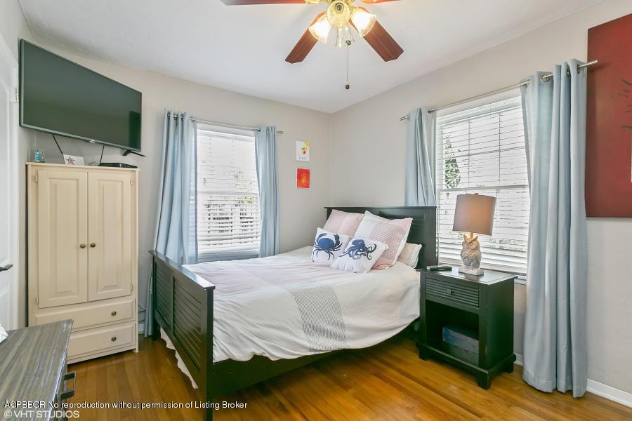 831 Hampton Road West Palm Beach, FL 33405 - Photo 8 of 10 a bedroom with a bed and a chandelier
