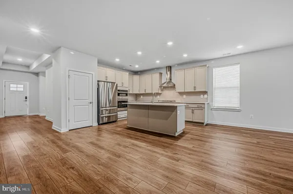 a large kitchen with stainless steel appliances granite countertop a stove a sink and a refrigerator