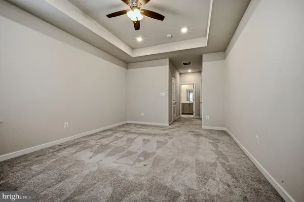 en empty room with a ceiling fan and a window