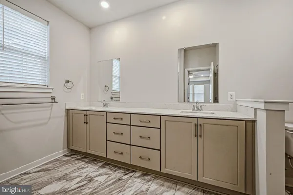 a spacious bathroom with a granite countertop sink and a mirror