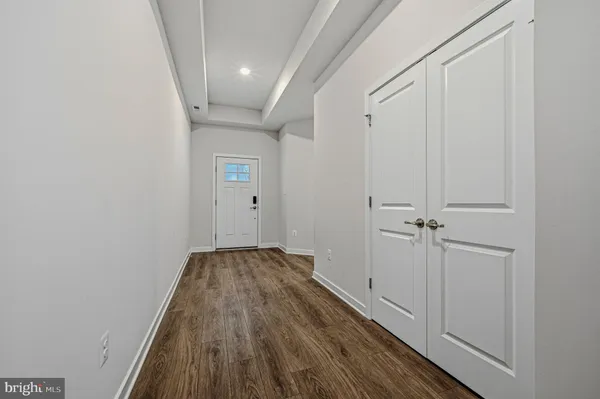 a view of a hallway with wooden floor and a ceiling fan