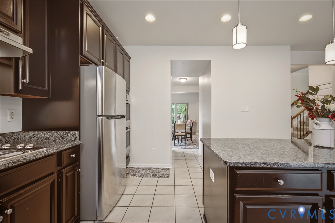 9013 Bailey Hill Road Midlothian, VA 23112 - Photo 22 of 56 Kitchen featuring dark wood cabinetry, granite cou