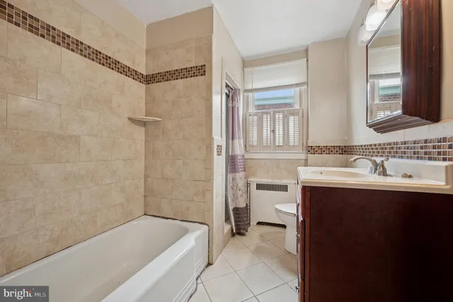 a bathroom with a bathtub a sink a toilet and a mirror