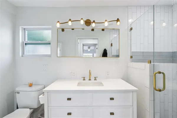 a bathroom with a sink vanity mirror and toilet