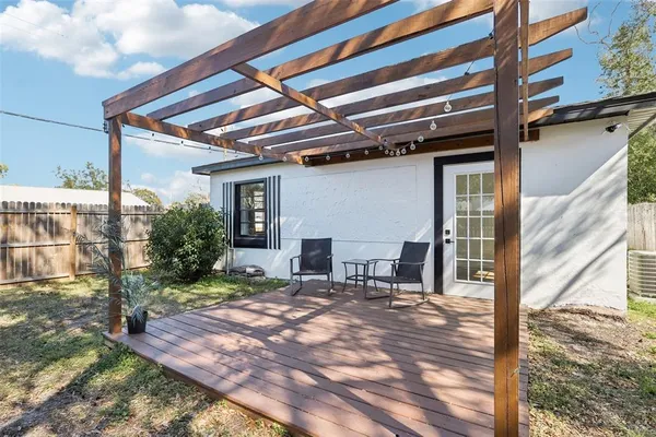 a view of a patio with table and chairs with wooden floor and fence