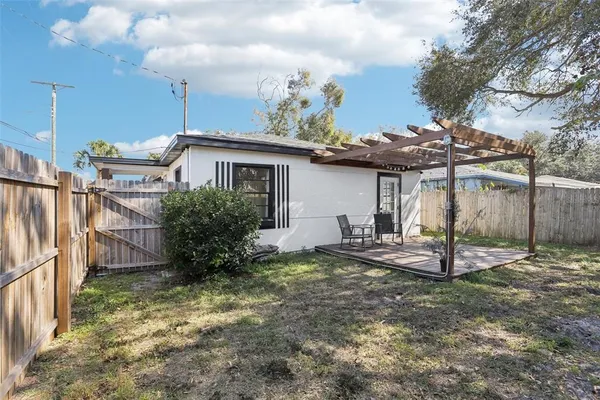 a view of a house with backyard and a tree