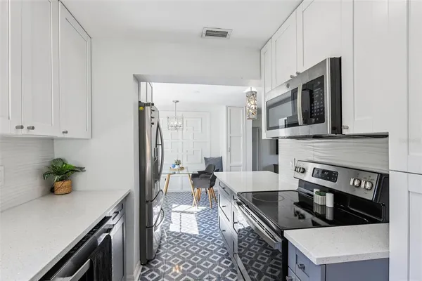 a kitchen with stainless steel appliances granite countertop a stove a sink and a microwave