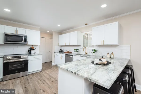 a kitchen with granite countertop a sink appliances and cabinets