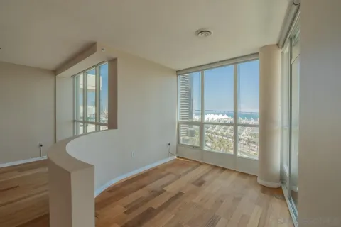 a view of hallway with a large window and wooden floor