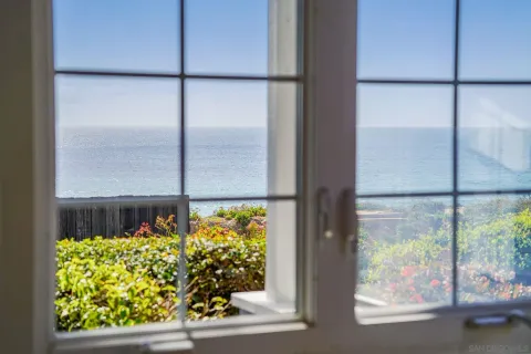 a living room with furniture a large window and a chandelier