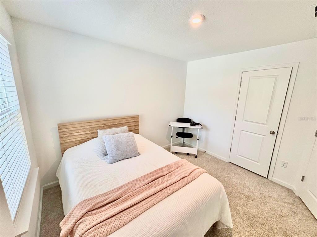 1005 Spring Palms Loop Orlando, FL 32828 - Photo 15 of 29 a bedroom with a bed and a mirror