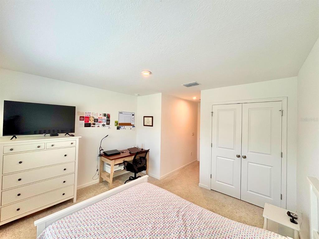 1005 Spring Palms Loop Orlando, FL 32828 - Photo 16 of 29 a bedroom with a bed and flat screen tv