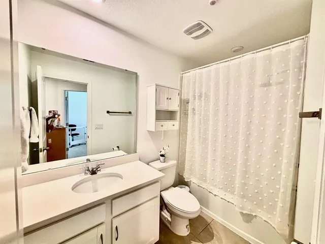 a bathroom with a sink vanity mirror and toilet