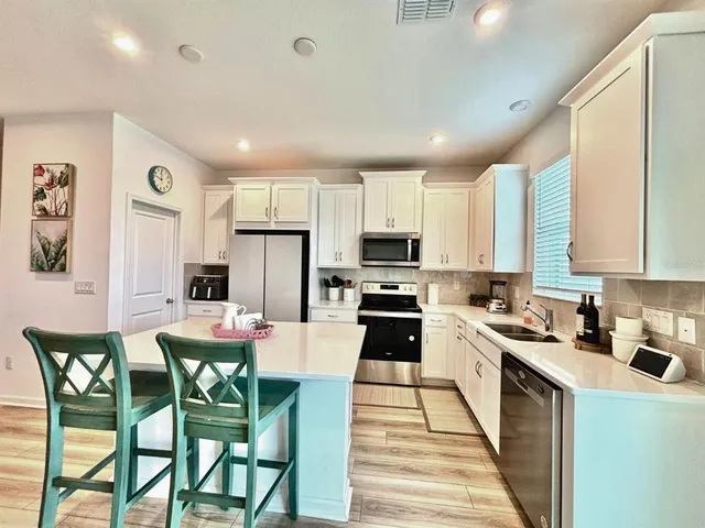 a kitchen with kitchen island granite countertop wooden cabinets and stainless steel appliances