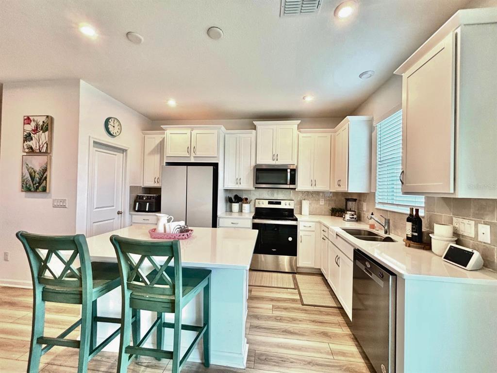 1005 Spring Palms Loop Orlando, FL 32828 - Photo 18 of 29 a kitchen with kitchen island granite countertop wooden cabinets and stainless steel appliances