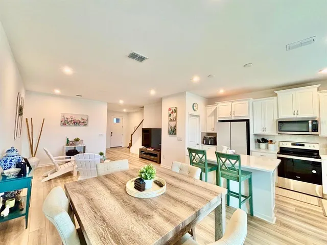a large kitchen with sink a refrigerator and dining table