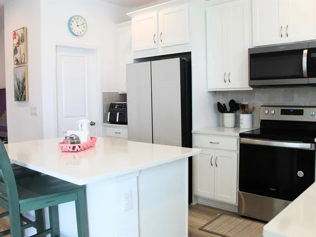a kitchen with stainless steel appliances a microwave a sink and cabinets