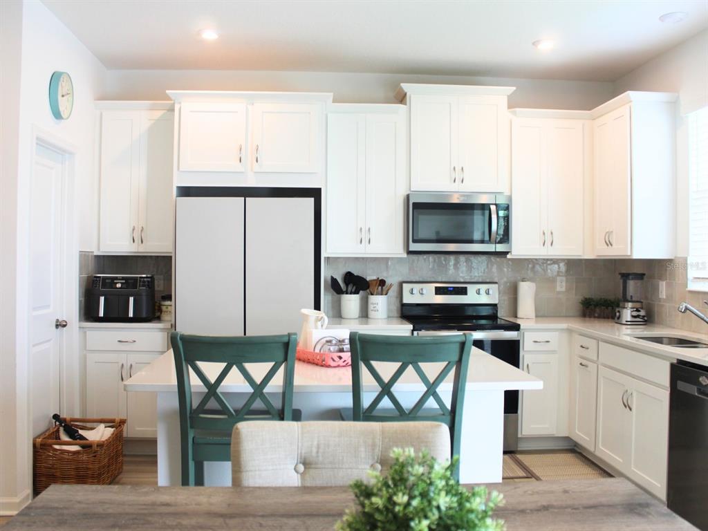 1005 Spring Palms Loop Orlando, FL 32828 - Photo 21 of 29 a kitchen with stainless steel appliances a stove a sink a microwave a refrigerator and cabinets