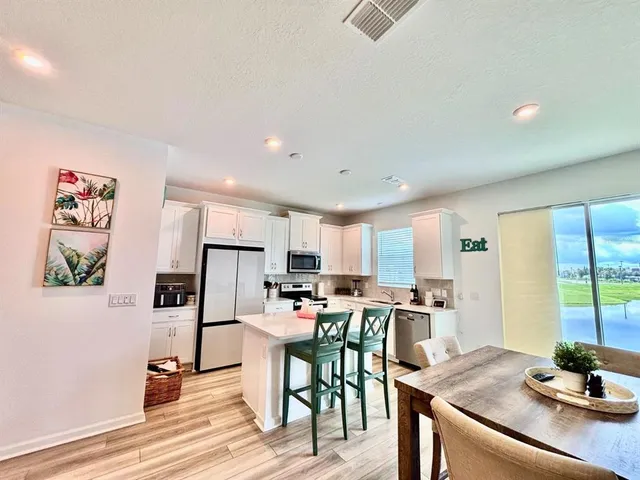 a kitchen with stainless steel appliances kitchen island granite countertop a sink cabinets and wooden floor
