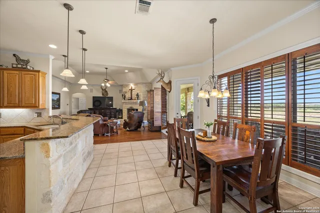 a view of a dining room with furniture a chandelier and wooden floor