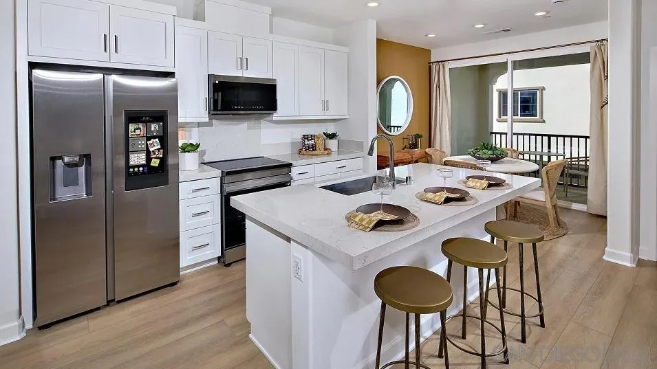1412 Mountain Laurel Road San Marcos, CA 92078 - Photo 3 of 16 a kitchen with stainless steel appliances granite countertop a refrigerator a stove a sink and a dining table with wooden floor