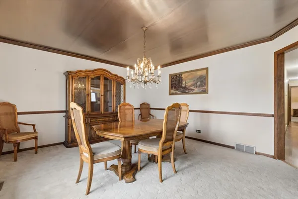 a view of a dining room with furniture and chandelier