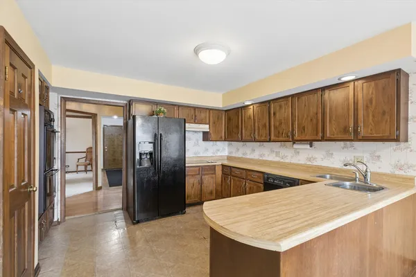 a kitchen with a sink refrigerator and cabinets
