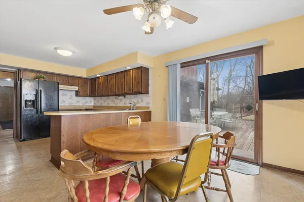 a dining room with stainless steel appliances a table chairs and chandelier