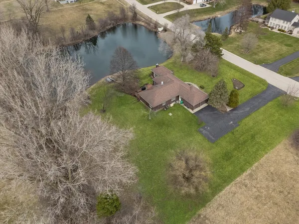 an aerial view of a house with garden space and a lake view