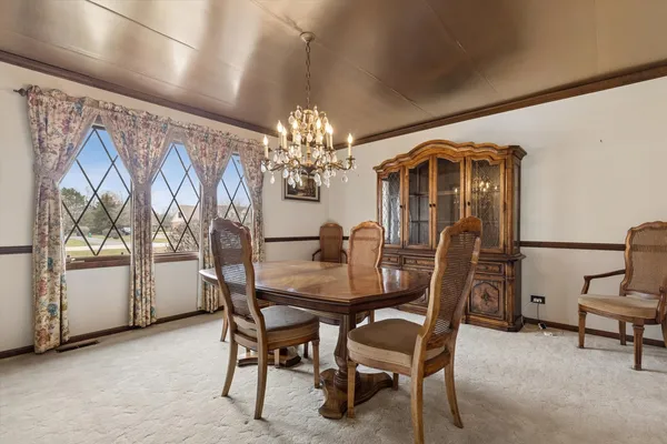 a view of a dining room with furniture and chandelier
