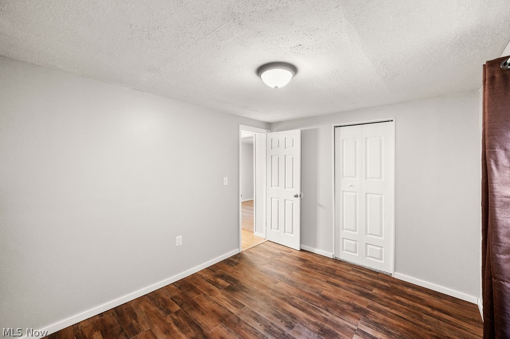 58 Rock Ridge Road Mineral Wells, WV 26150 - Photo 13 of 38 Wood-finish flooring with light gray walls, a flush-mount ceiling light, and white paneled doors