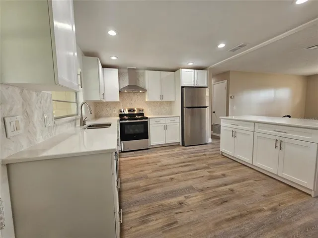 a kitchen with stainless steel appliances granite countertop a sink stove and refrigerator