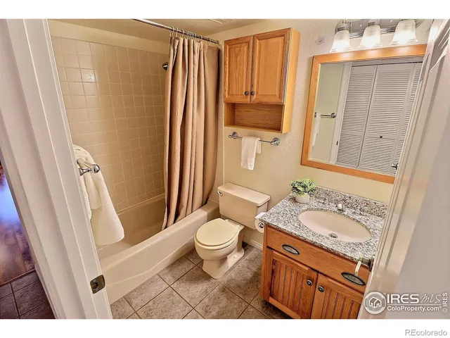 a bedroom with a large bed a chandelier and closet