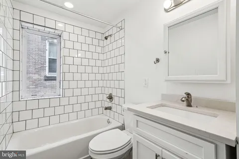 a view of a kitchen with refrigerator and wooden floor