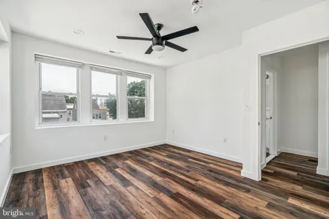a view of a room with wooden floor and a bathroom
