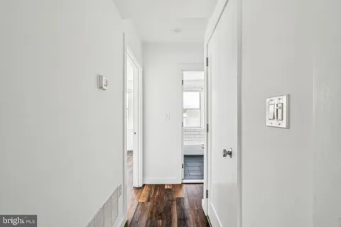 a view of a kitchen with refrigerator and wooden floor