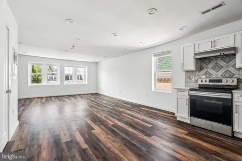 a view of kitchen with white cabinets and potted plants