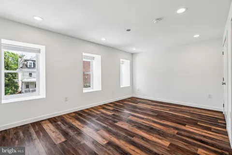 a view of an empty room with a fireplace and a window