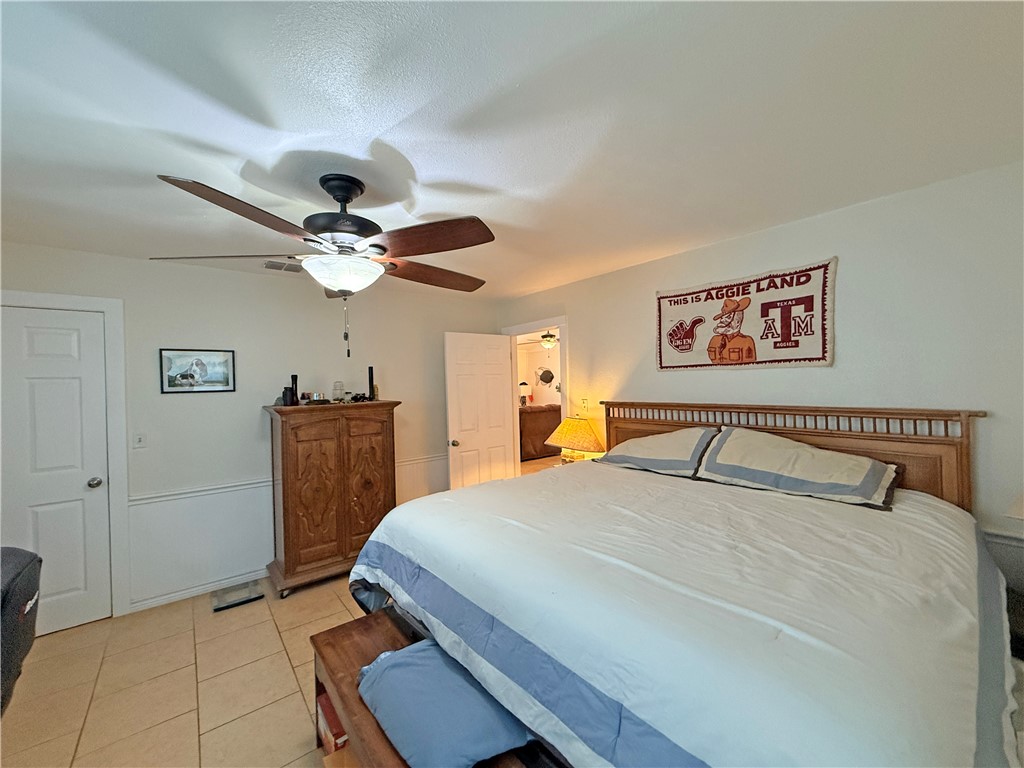 105 Copano Cove Road Rockport, TX 78382 - Photo 14 of 40 a bedroom with a bed and a chandelier