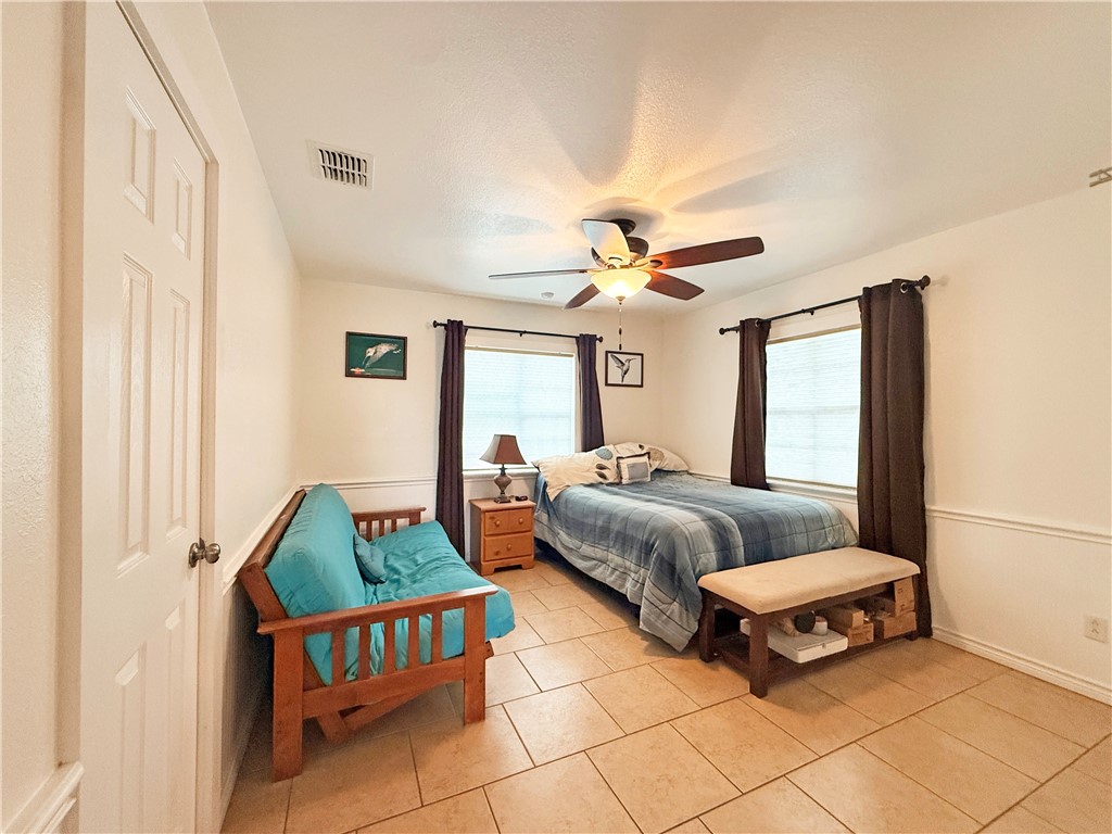 105 Copano Cove Road Rockport, TX 78382 - Photo 17 of 40 a bedroom with bed and window