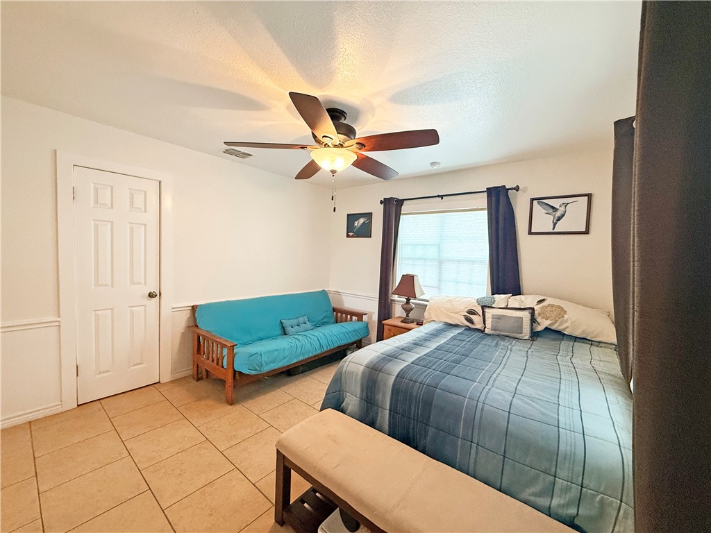 105 Copano Cove Road Rockport, TX 78382 - Photo 18 of 40 a bedroom with two beds and a chandelier