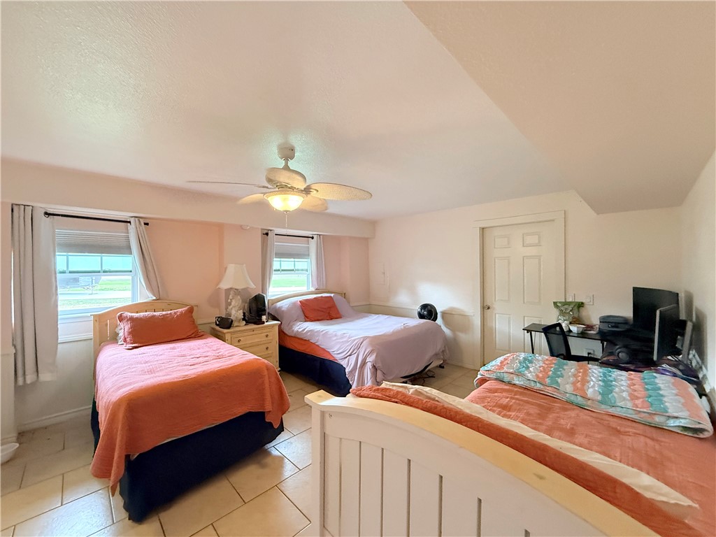 105 Copano Cove Road Rockport, TX 78382 - Photo 25 of 40 a bedroom with two beds and a dresser with wooden floor