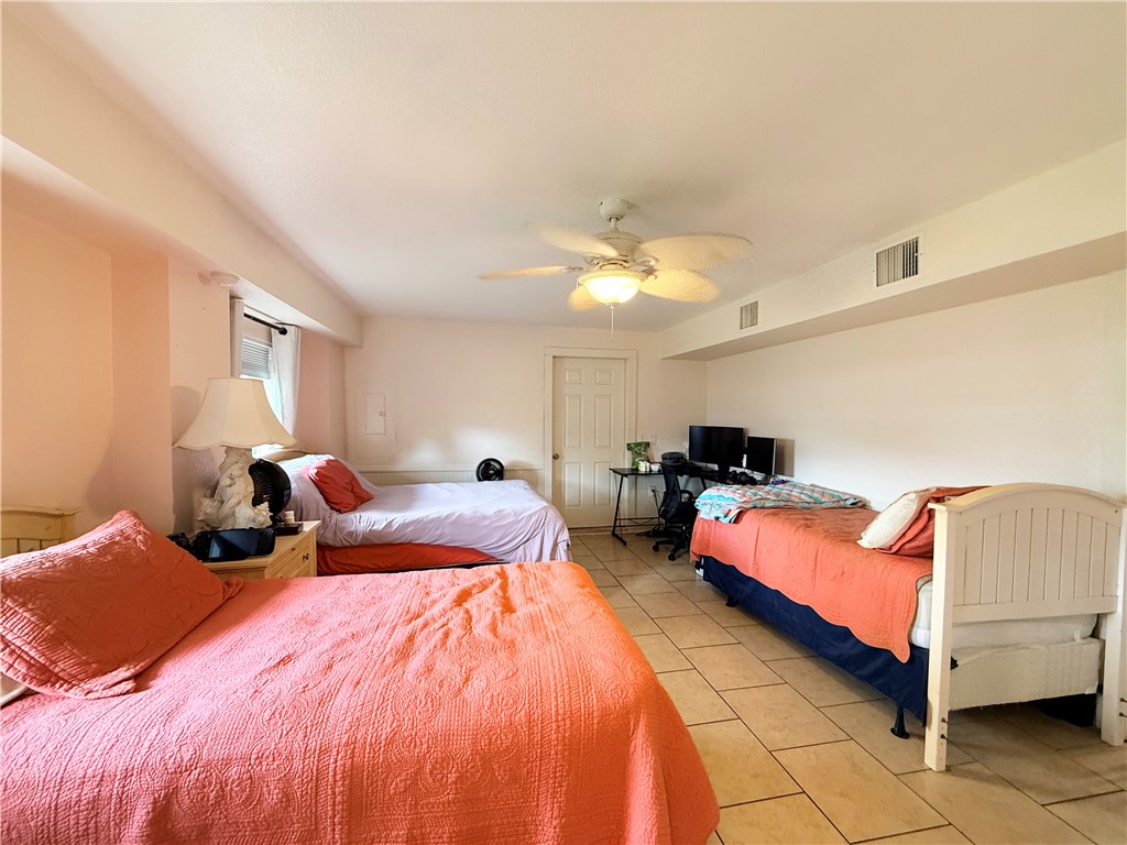 105 Copano Cove Road Rockport, TX 78382 - Photo 26 of 40 a bed room with a bed and a chandelier