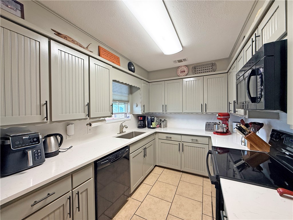 105 Copano Cove Road Rockport, TX 78382 - Photo 10 of 40 a kitchen with a sink and cabinets