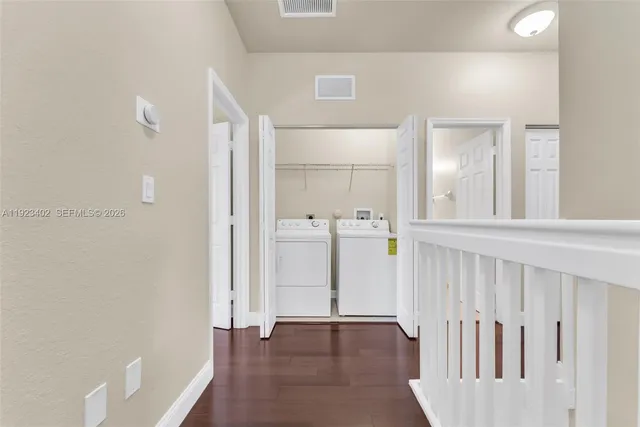 a view of a hallway with wooden floor and staircase