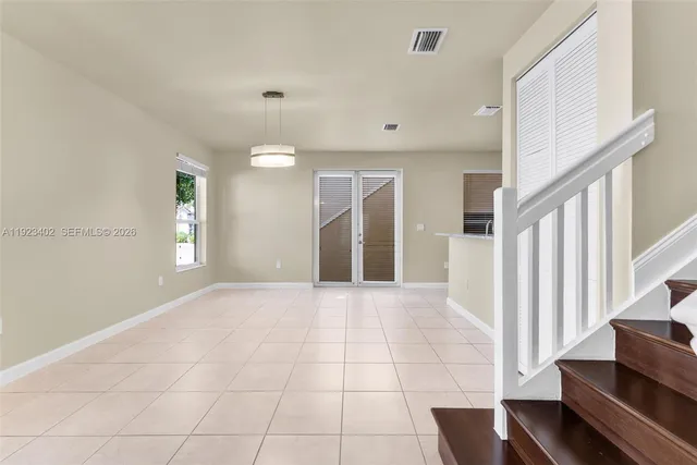 a view of an empty room with stairs and a window