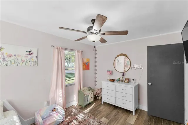 a room with a baby bed mirror and a window