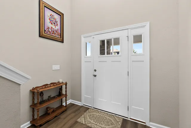 a view of a hallway with couches and dining room with wooden floor