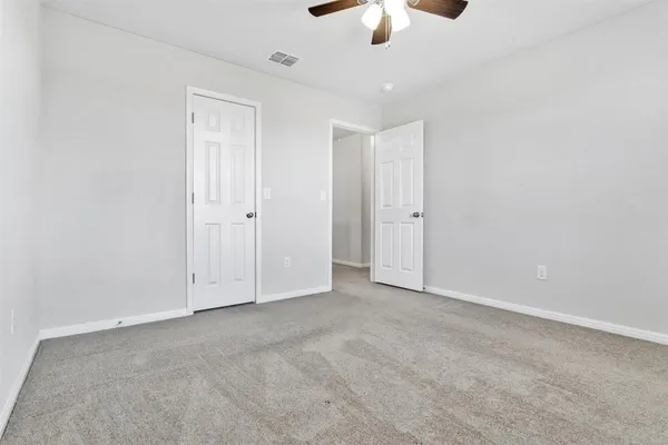 an empty room with chandelier fan